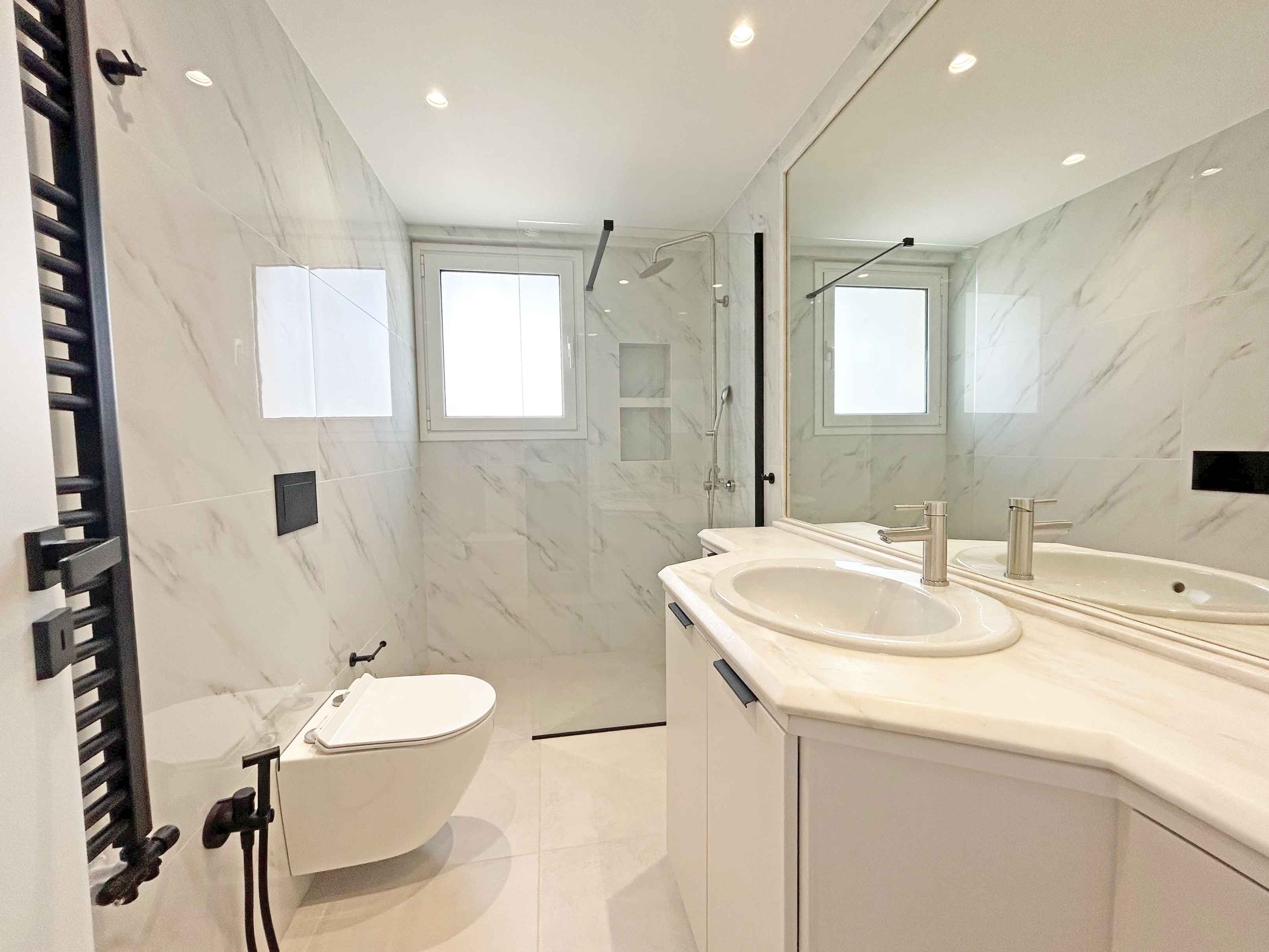 Μπάνιο με λευκό μάρμαρο και μαύρα αξεσουάρ