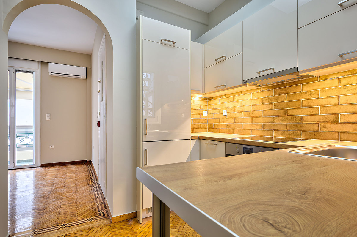 Κουζίνα με Λευκά Ντουλάπια και Εντοιχισμένο Ψυγείο