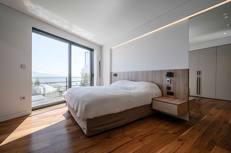 Master bedroom με ξύλινη κατασκευή πλάτης και κομοδίνα