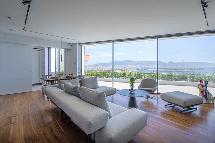 Σαλόνι με μεγάλα ανοίγματα και κινητό διαχωριστικό τοίχο κουζίνας